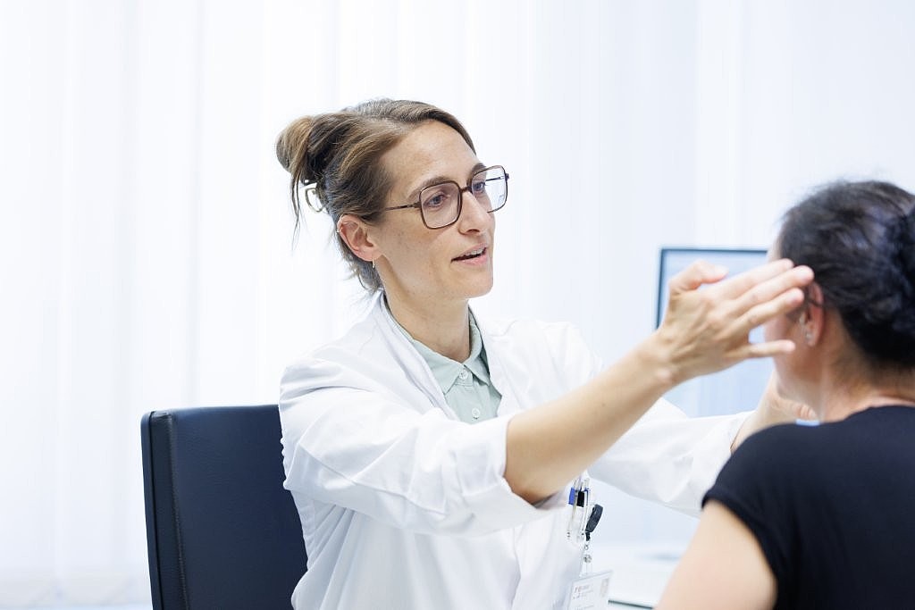 Ärztin im weißen Kittel im Gespräch mit Patientin